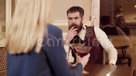 恋爱中的情侣帅哥在餐馆和可爱的女人调情有胡子的男人和年轻的金发女郎调情视频的预览图
