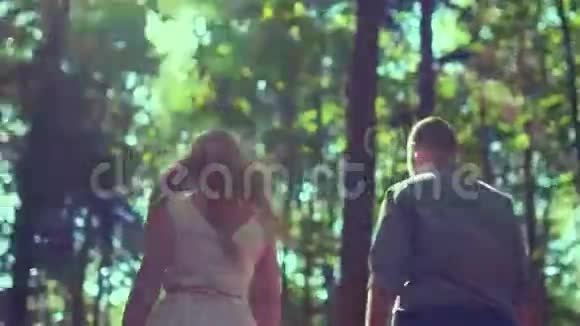 阳光明媚的一天一对夫妇在森林里散步视频的预览图