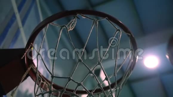 在探照灯的背景下把一个球扔进篮球圈慢动作视频的预览图