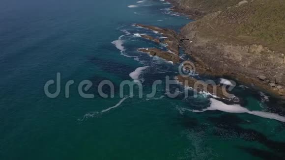 无人驾驶飞机的海浪拍打着岩石海岸的顶部视频的预览图