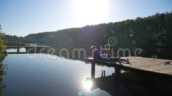 湖边的风景芦苇和母亲带着女儿在码头上视频的预览图