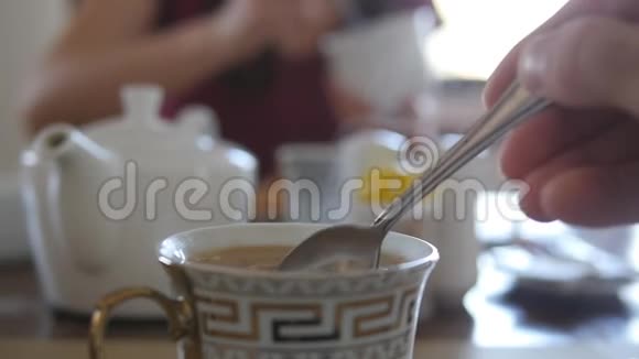 女性手在一杯热咖啡或茶中搅拌糖或牛奶慢动作视频的预览图