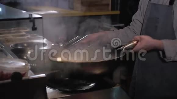 厨师油炸蔬菜和带火的肉在炒锅商业厨房烹饪视频的预览图