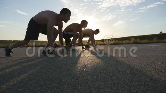 一群运动员在比赛前蹲在起跑线上一起跑步三个肌肉发达的年轻人视频的预览图