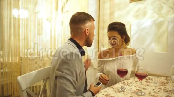 年轻漂亮的夫妇在餐馆里用一杯酒自拍视频的预览图
