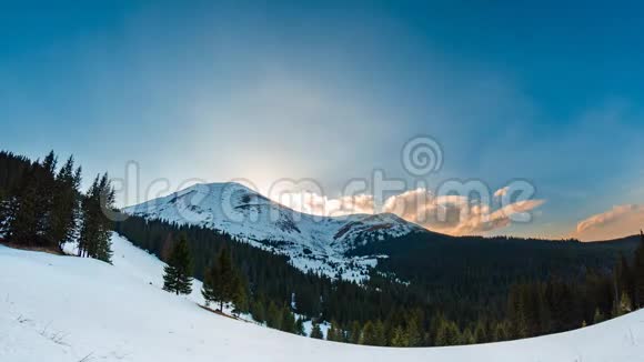 在美丽的山区地形中随着云和雪的推移冬季日落时间逐渐流逝视频的预览图