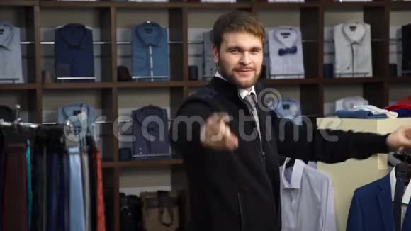 年轻有魅力的男人留着胡子穿着商务西装在一家男装店跳舞视频的预览图