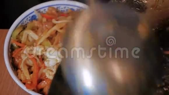 厨师在碗里放蔬菜和肉的中国面条近距离射击视频的预览图