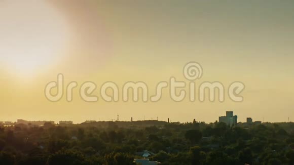 小城市的日落太阳落山地平线上房子的灯光亮起白天到晚上视频的预览图