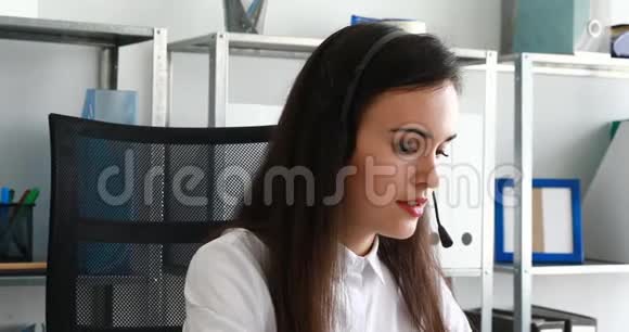 现代办公室里戴着耳机说话的女人视频的预览图