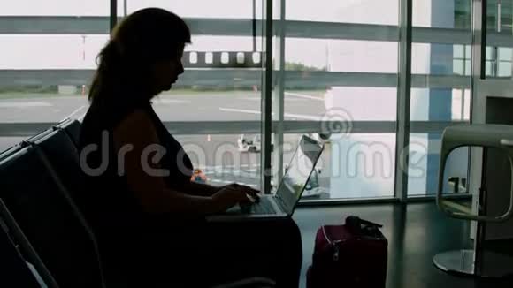 在机场用笔记本电脑工作的女人视频的预览图
