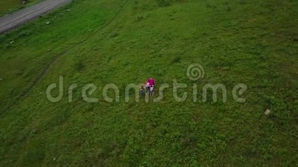 空中飞行幸福的一家人挥手对着镜头微笑带着小孩在山上徒步旅行的父母视频的预览图