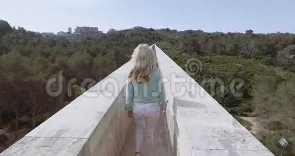 旅游女孩穿过古老的魔鬼渡槽视频的预览图