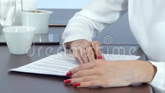 女人手里拿着红指甲签合同视频的预览图
