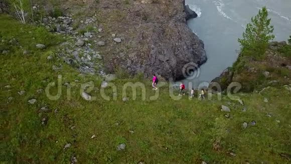 空中飞行徒步旅行中的幸福家庭父母带着年幼的孩子沿着河边的一条山路走西伯利亚阿尔泰视频的预览图