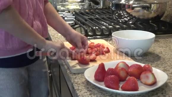 女孩的手刀切草莓的慢动作视频的预览图