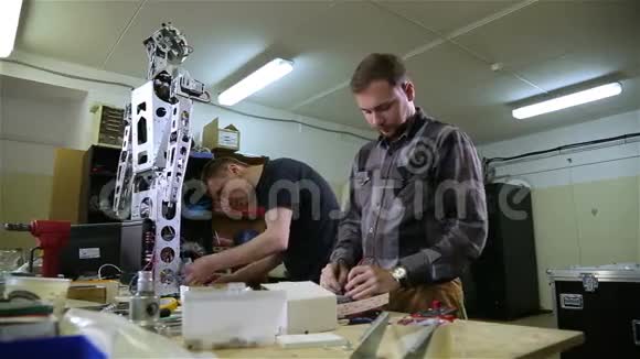 两个人在车间修理机器人视频的预览图