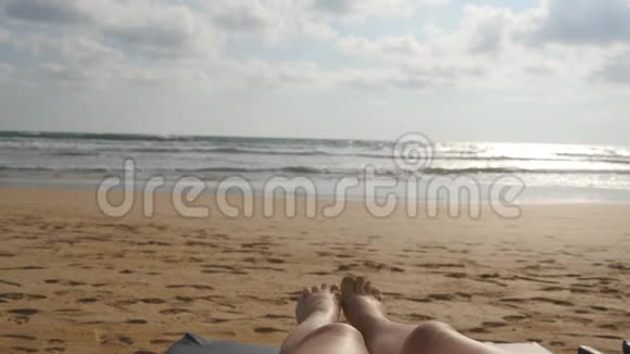 女足在海边玩耍在暑假旅行期间美丽的年轻女子在海边放松的腿视频的预览图