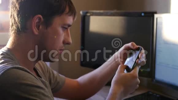 一个年轻人开着一个手指在监视器电话上看着远处4K视频的预览图