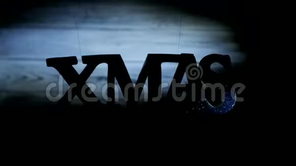 圣诞铭文XMAS自由地悬挂在空中白色的木制背景上上面有一束来自阳光的光线视频的预览图