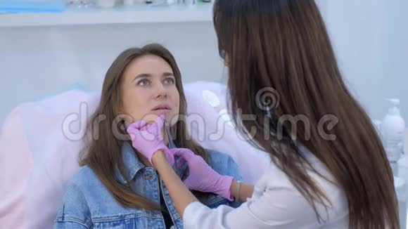 美容医生在女性嘴唇上进行注射以达到体积校正的形状视频的预览图