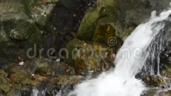 倾斜瀑布坠落撞击溅到河面的岩石视频的预览图