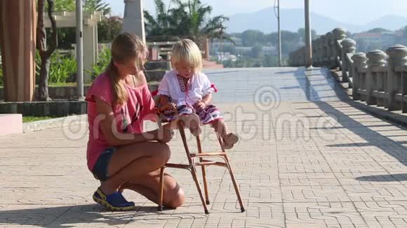 穿着乌克兰国家衬衫的金发小女孩坐在儿童椅子上视频的预览图