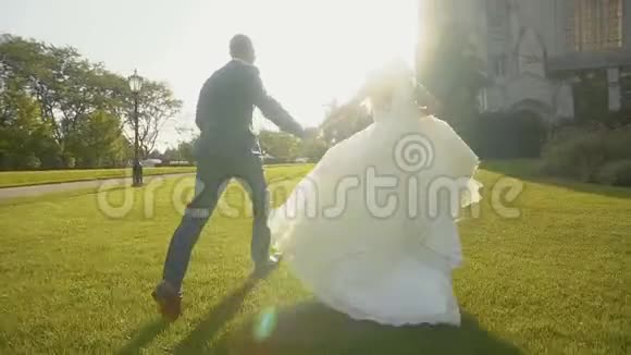 在阳光明媚的日子里新娘和新郎牵手在大宅附近奔跑视频的预览图