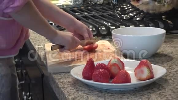 女孩的手刀切草莓的慢动作视频的预览图