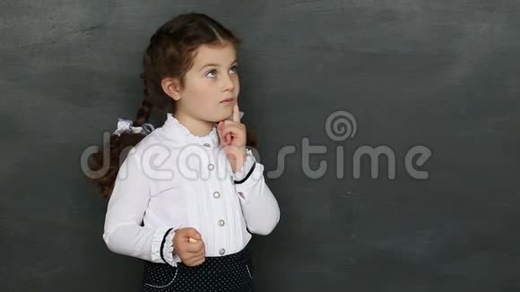 一个小女孩站在黑板前视频的预览图