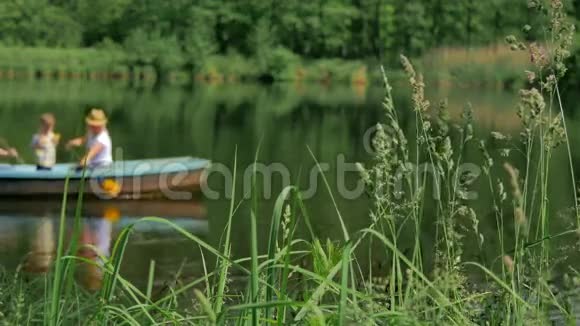 背景模糊家人漂浮在湖面上的船上视频的预览图