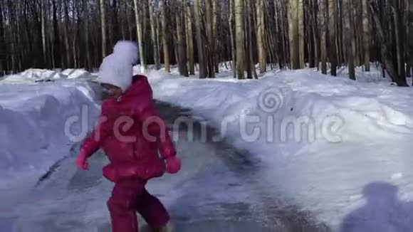 小女孩正在公园的冰道上跳舞女孩很高兴很快变得温暖春天晴朗的早晨视频的预览图
