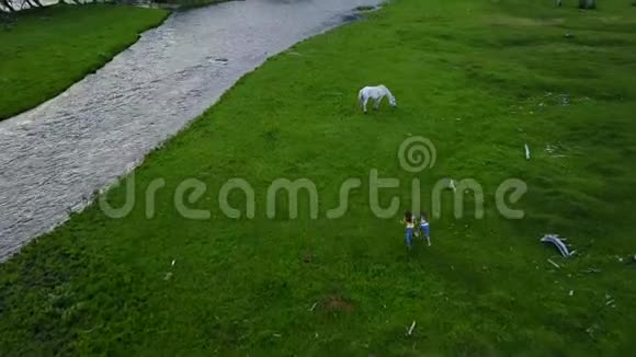 空中飞行小女孩穿过一片草地孩子们在户外玩耍和玩得很开心姐姐跑到河边视频的预览图