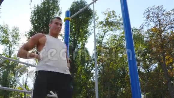英俊的运动员在城市公园训练前热身年轻强壮的肌肉男在锻炼前伸展身体视频的预览图