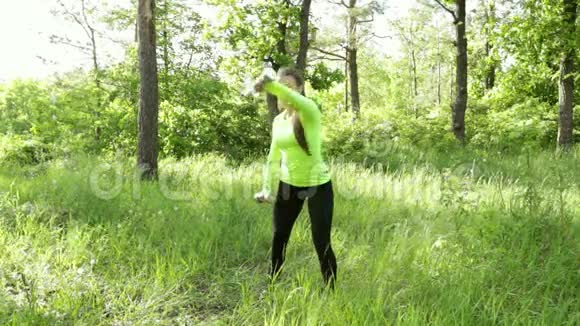 在森林附近的公园里和哑巴一起锻炼的年轻女子视频的预览图