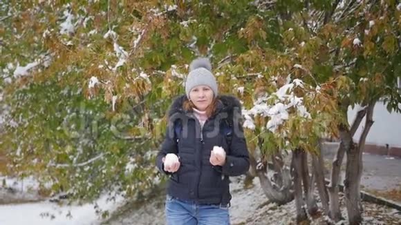 女孩在秋天的公园里扔雪球视频的预览图