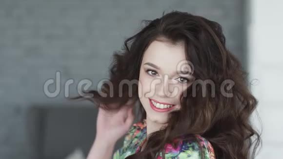 迷人的女孩带着迷人的微笑在相机上摆姿势一个年轻的黑发女人的肖像慢动作视频的预览图