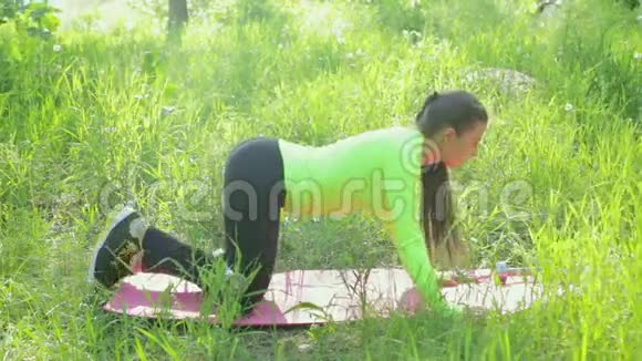 在公园锻炼身体的女人用哑铃做腿托视频的预览图