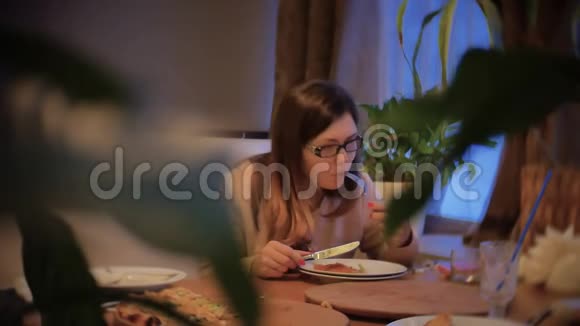 女孩吃比萨饼坐在咖啡馆晚上室内晚餐快餐慢动作视频视频的预览图