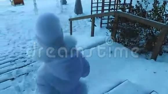 女孩下了满是雪的楼梯孩子正在公园里散步冬霜日视频的预览图