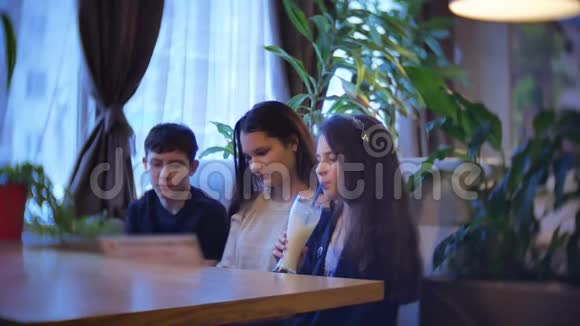 一群孩子在咖啡馆里吃快餐青少年儿童咖啡馆慢动作视频乐趣欢乐视频的预览图
