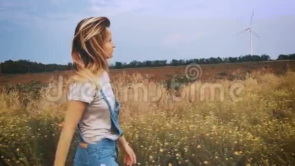 快乐的年轻女孩走在田野里慢动作视频的预览图