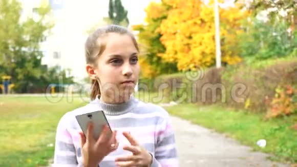 十几岁的女孩用她的智能手机说话视频的预览图