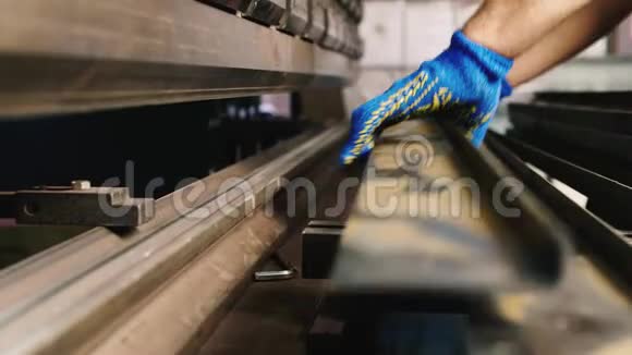带有金属工件的工人的手为折弯机提供零件视频的预览图