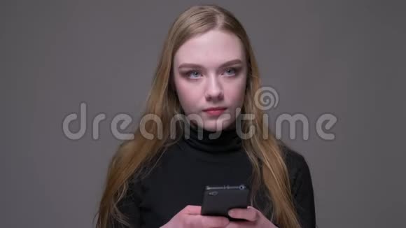 一位年轻漂亮的黑发女性的特写肖像她用电话愉快地微笑着背景被隔绝在外视频的预览图