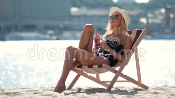 迷人的女人在沙滩上享受日光浴视频的预览图
