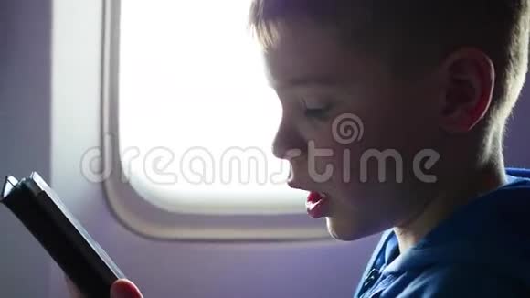小孩把手机放在靠近窗户的飞机上视频的预览图
