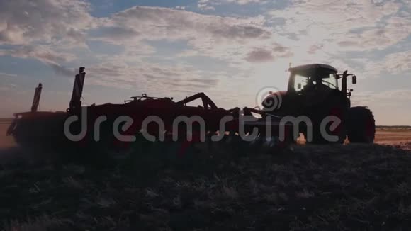 斯塔迪加姆拍摄拖拉机在日落时耙田视频的预览图