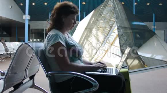 在机场用笔记本电脑工作的女人视频的预览图