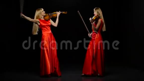 两个女人在演奏中提琴工作室黑色背景视频的预览图